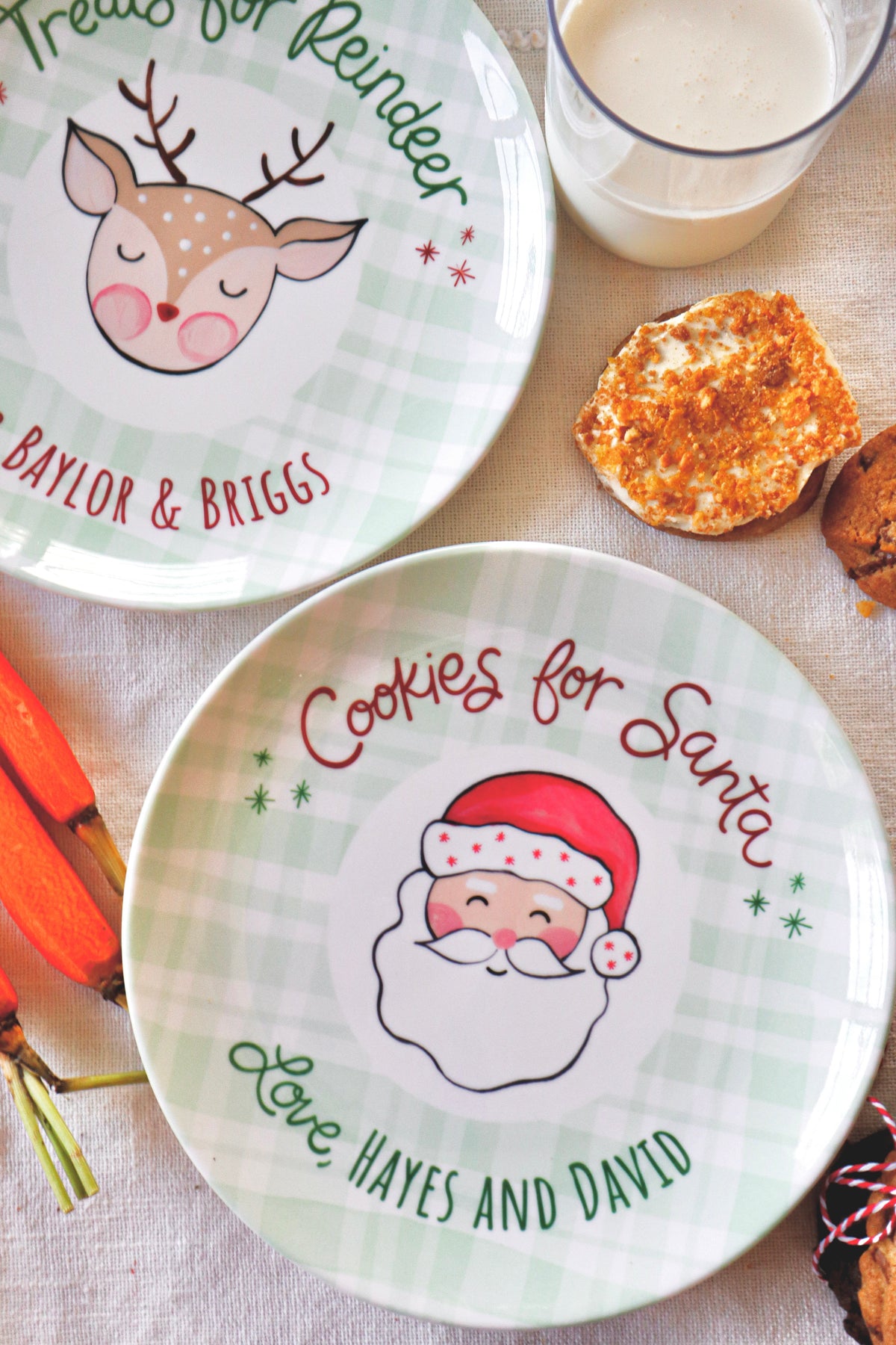 Two personalized Christmas ceramic plates. One plate shows a reindeer and the text 'Treats for Reindeer' and personalized names, and the other shows Santa with the text 'Cookies for Santa' and 'Love, custom names.