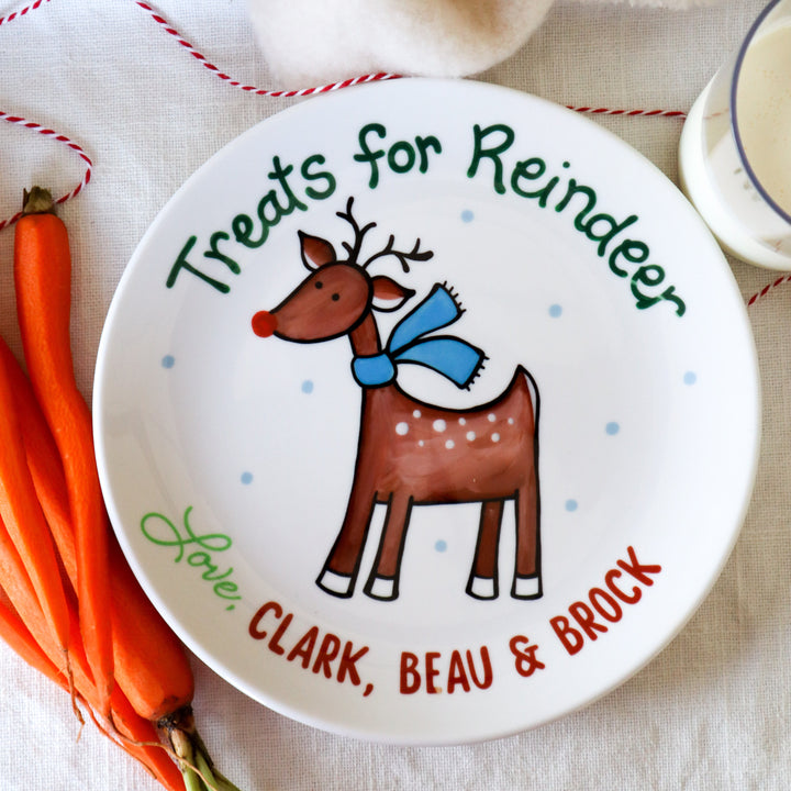 Treats for Reindeer ceramic plate. Personalized with names. Reindeer is brown with scarf. Carrots are on table